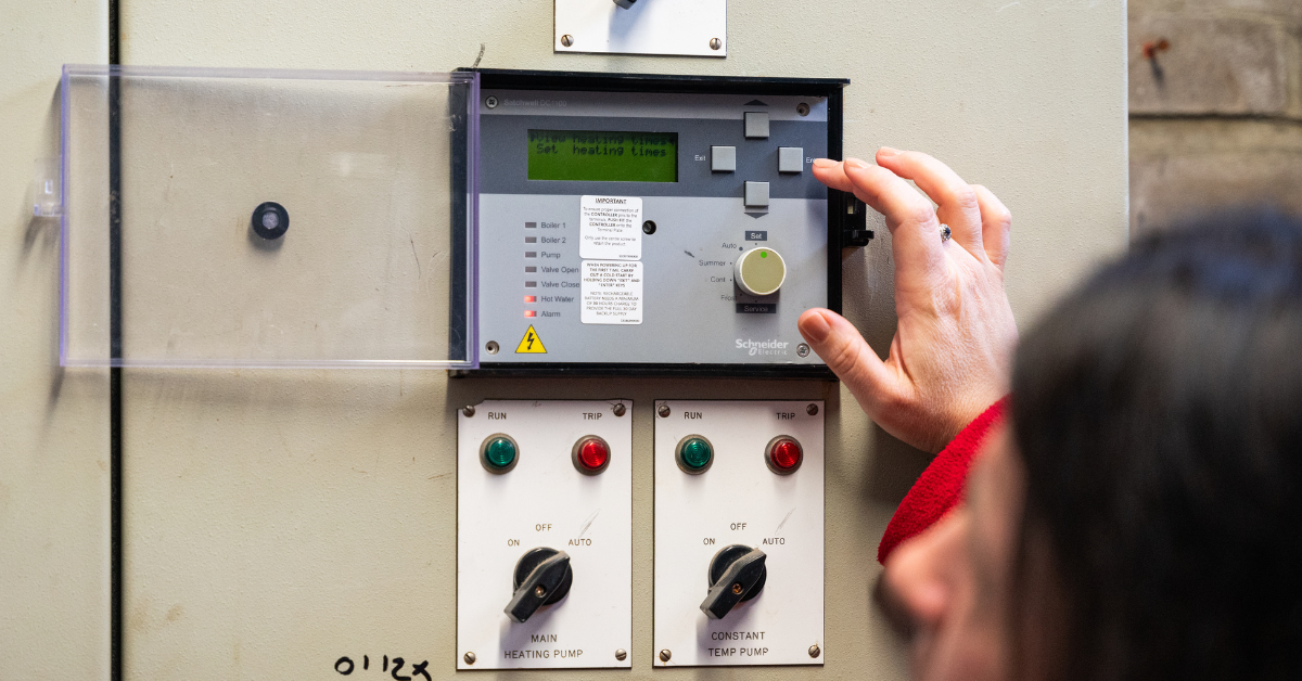 Facilities staff member adjusts a school's heating times.