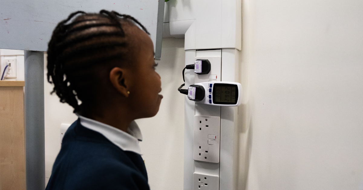 A primary school student looks at the read-out from an appliance energy monitor.
