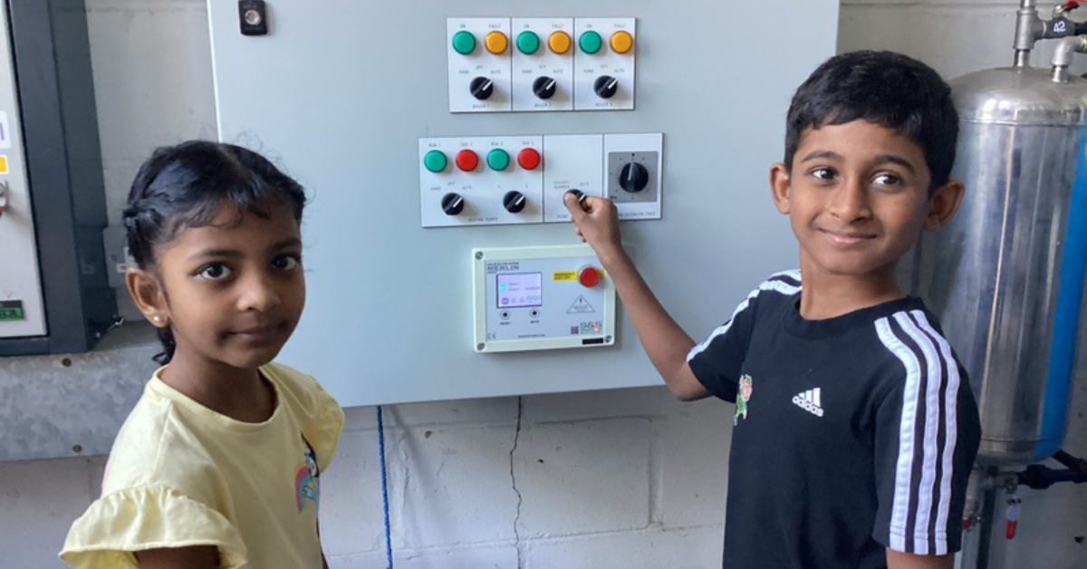 Two primary students help switch the boiler off for the holiday