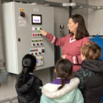 A primary school headteacher giving pupils a tour of the school's boiler room.